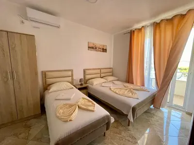 two beds in a room with a window at Dragaj Apartments in Ulcinj