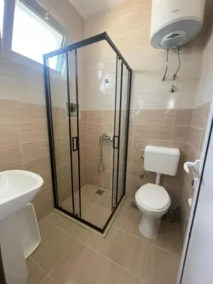 a bathroom with a shower and a toilet and a sink at Dragaj Apartments in Ulcinj