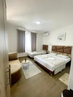 a hotel room with two beds and a couch at Dragaj Apartments in Ulcinj