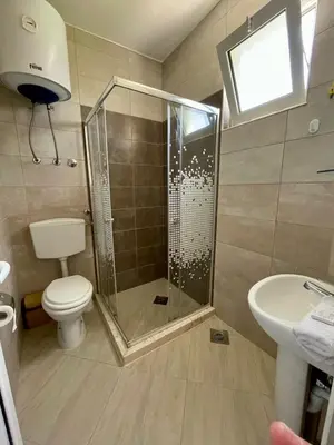 a bathroom with a shower and a toilet and a sink at Dragaj Apartments in Ulcinj