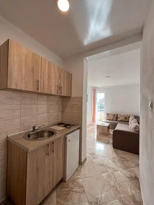 a kitchen with a sink and a couch in a room at Dragaj Apartments in Ulcinj