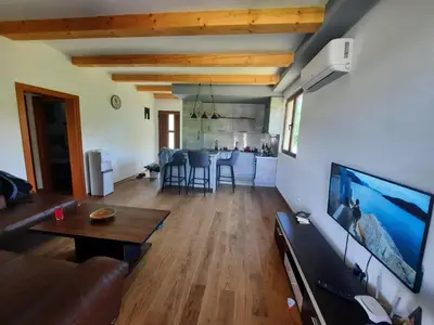 a living room with a couch and a tv on a wall at Orahovo stone vilas in Virpazar