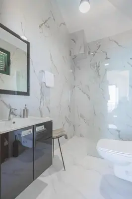 a white bathroom with a sink and a toilet at Villa Krstac in Budva