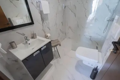 a white bathroom with a sink and a toilet at Villa Krstac in Budva