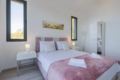 a bedroom with a large white bed with two tables at Villa Krstac in Budva