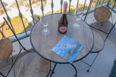 a glass table with a bottle of wine and two wine glasses at Villa Krstac in Budva