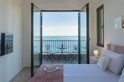 a bedroom with a bed and a balcony with a view at Villa Krstac in Budva
