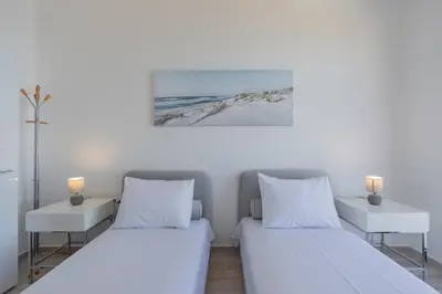 two beds in a room with two tables and two lamps at Villa Krstac in Budva