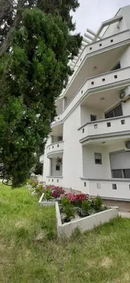 a large white building with flowers in a yard at STANDART Premium in Ulcinj