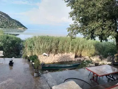 a green boat sitting on the side of a lake at Apartment Lake Oasis ''Oko'' in Krnjice