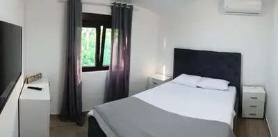 a bedroom with a white bed and a window at MIA CASA Apartmens in Budva