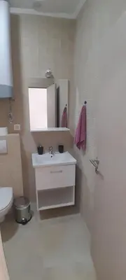 a bathroom with a sink and a toilet and a mirror at MIA CASA Apartmens in Budva