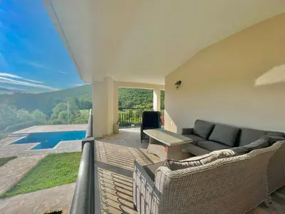 a living room with a couch and a table on a balcony at Villa Petra Zagora in Zagora