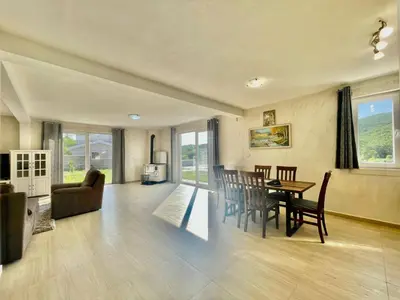 a dining room and living room with a table and chairs at Villa Petra Zagora in Zagora