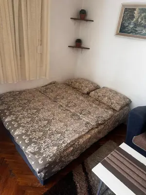 a bed in a room with a bedspread at A-D free wi-fi internet, air conditioner,free parking in Podgorica
