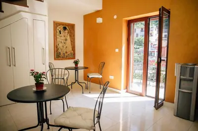 a dining room with a table and chairs and a window at Filip Deluxe Rooms in Kotor