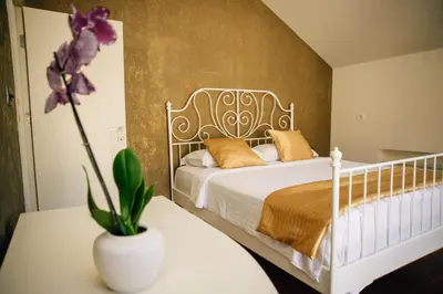 a bedroom with a white bed with a flower on a table at Filip Deluxe Rooms in Kotor