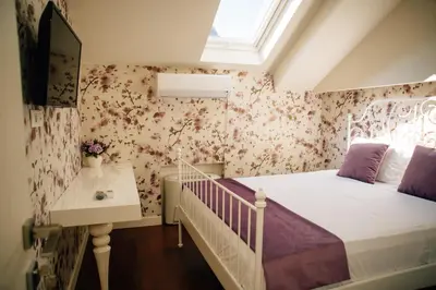 a bedroom with a bed and a desk and a window at Filip Deluxe Rooms in Kotor