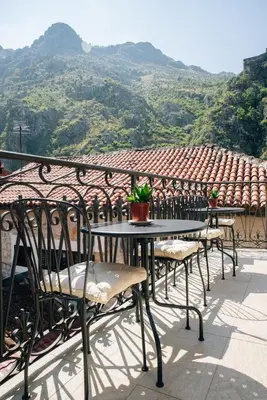 a table and chairs on a balcony with a view at Filip Deluxe Rooms in Kotor