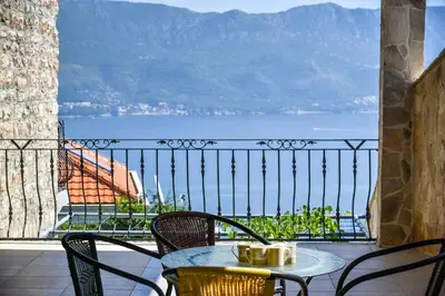 a table and chairs on a balcony with a view of the ocean at Studios Kalina in Budva