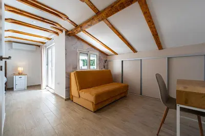 a living room with a couch and a table at Cosy Duplex near Bus Station in Budva