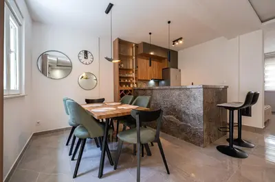 a dining room with a wooden table and chairs at Cosy Duplex near Bus Station in Budva