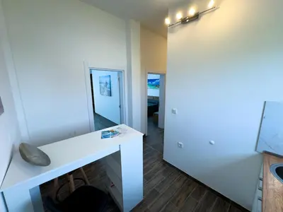 a room with a white desk and a hallway at Adla Apartmani in Ulcinj