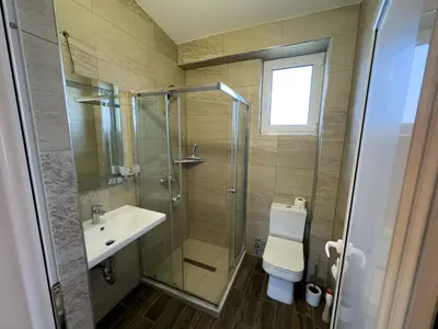 a bathroom with a shower and a toilet and a sink at Adla Apartmani in Ulcinj