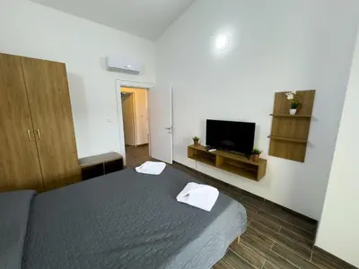 a bedroom with a bed and a flat screen tv at Adla Apartmani in Ulcinj