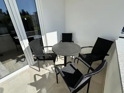 a table and chairs sitting on a balcony at Adla Apartmani in Ulcinj