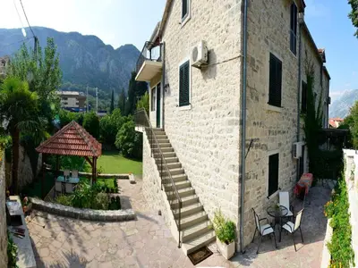a stone building with a staircase next to a patio at Villa Andrea Apartments with parking in Kotor
