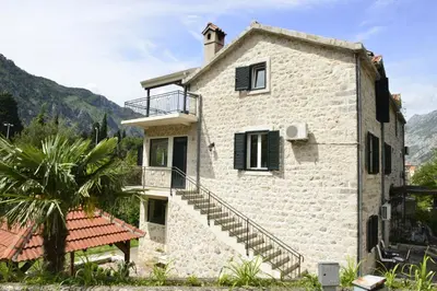 a stone house with stairs leading up to it at Villa Andrea Apartments with parking in Kotor