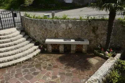 a bench sitting next to a stone wall at Villa Andrea Apartments with parking in Kotor