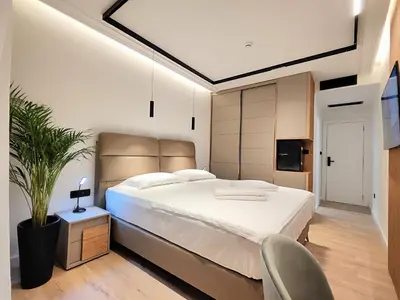 a bedroom with a large white bed and a chair at AMD Premium rooms Budva in Budva