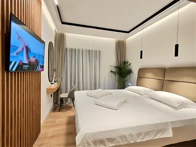 a bedroom with a bed and a flat screen tv at AMD Premium rooms Budva in Budva