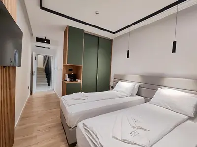 two beds in a small room with green cabinets at AMD Premium rooms Budva in Budva