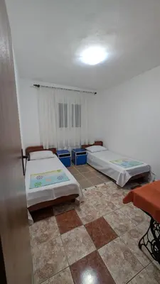 two beds in a room with a tiled floor at Private guest-house Gutic in Sutomore