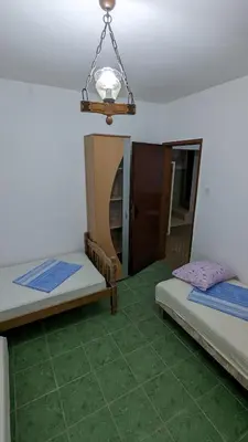 a room with two beds and a chandelier at Private guest-house Gutic in Sutomore
