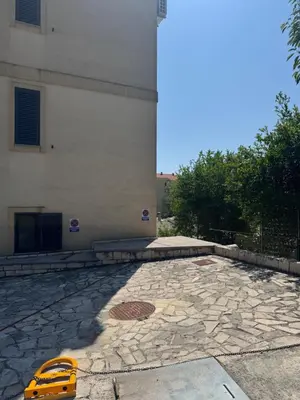 a building with a yellow car parked in front of it at Cozy studio apartment in Petrovac in Petrovac na Moru