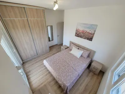 a small bedroom with a bed and a painting on the wall at Angie's in Ulcinj