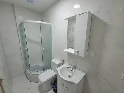 a white bathroom with a toilet and a sink at Angie's in Ulcinj