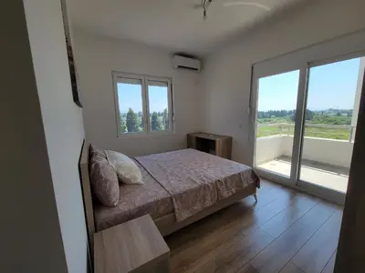 a bedroom with a bed and a large window at Angie's in Ulcinj