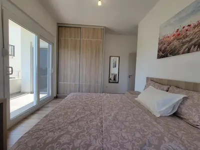 a bedroom with a large bed and a large window at Angie's in Ulcinj