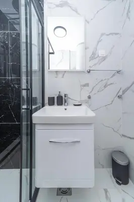 a white bathroom with a sink and a shower at New Renovated Warm Cozy Fully Equipped One Bedroom Apartment in Budva, Free Parking, Ideal for Long Stays in Budva