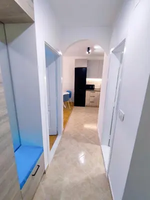 a hallway with a blue bench in a room at New Renovated Warm Cozy Fully Equipped One Bedroom Apartment in Budva, Free Parking, Ideal for Long Stays in Budva