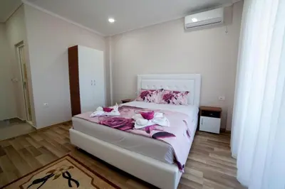 a bedroom with a bed with pink sheets and pink flowers at L&I Villa in Ulcinj