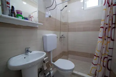 a bathroom with a toilet and a sink and a shower at L&I Villa in Ulcinj