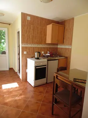 a small kitchen with a stove and a table at Apartments Macaso in Bar