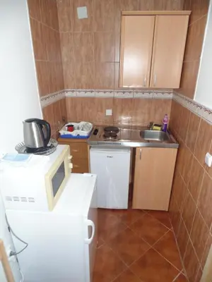 a small kitchen with a microwave and a sink at Apartments Macaso in Bar