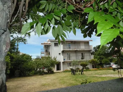 a building with two chairs in front of it at Apartments Macaso in Bar